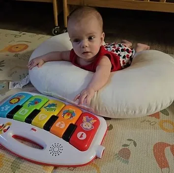 Infant during tummy time with toy piano