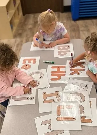 Pre-K children tracing alphabet letters