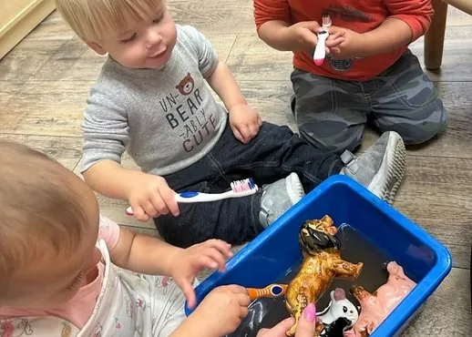 Toddlers exploring water sensory bin